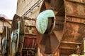 An old, rusty steel fan sits among weathered industrial architecture, a reminder of days gone by Royalty Free Stock Photo