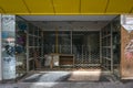 Duisburg, Germany, June 25, 2022: Closed city store locked with a grid after insolvency in a economic crisis, first graffiti