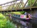 Narrowboat passing under steel girder bridge