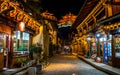 Dukezong Tibetan old town scenic street view with shops and Dafo temple illuminated at night in background in Shangri-La Yunnan