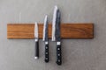 Dull Japanese kitchen knives stick on magnet cover with wood on concrete wall