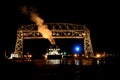 Duluth Minnesota aerial lift bridge with ore ship leaving harbor at night Royalty Free Stock Photo