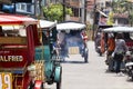 Dumaguete, Philippines - 13 May 2017: city street view with local people and tricycles.