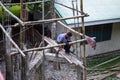 Dumaguete, the Philippines - 25 Oct 2020: worker on concrete tower. Reconstruction of rustic building