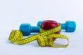 Dumbbell, apple and measuring tape