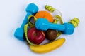 Dumbbell and apple, orange, banana, kiwi white background Royalty Free Stock Photo