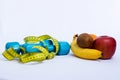 Dumbbell and apple, orange, banana, kiwi white background Royalty Free Stock Photo