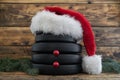 Dumbbell barbell weight plates, shaped as snowman in red Santa Claus Christmas hat.