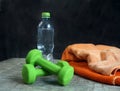 dumbbell towel and bottle of water on the table image of a sporty lifestyle