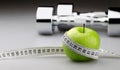 Dumbbells, Apple and Tape Measure on Gray Royalty Free Stock Photo