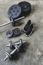 dumbbells and barbell with weight plates and sneakers on grungy