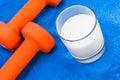 Dumbbells on blue cloth beside a glass of milk