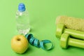 Dumbbells in bright green color, water bottle, measure tape, towel Royalty Free Stock Photo