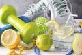 Dumbbells, glass of water with lemon, measuring tape, jump rope, ball, sneakers, lime, on a white