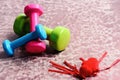 Dumbbells made of pink, green and cyan plastic near hearts Royalty Free Stock Photo