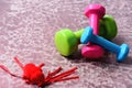 Dumbbells made of pink, green and cyan plastic near hearts Royalty Free Stock Photo