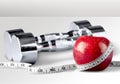 Dumbbells with measuring tape and apple for diet Royalty Free Stock Photo