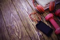 Dumbbells with towel on wooden background, concept preparing to fitness sports equipment top view. Headphones and phone. Music in