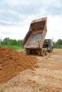 Dump-body truck unloads a ground Royalty Free Stock Photo