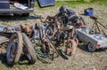 Dump the old broken rusty bicycles, motorcycles, toy cars, engines, tires and wheels with spokes in the open air on the ground