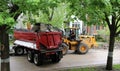 A dump truck accepts dirt and rocks from a wheeled bulldozer on a Chicago residential