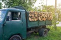 Dump truck with a body full of firewood. Truck loaded with stack of wooden logs to delivery for heating season. Firewood