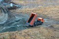 Dump truck unloading process. Dumper truck unloading earth material or soil at construction site during land improvement