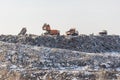 Dump trucks unloading garbage over vast landfill. Environmental pollution. Outdated method of wasate disposal. Surviva Royalty Free Stock Photo