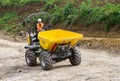 A dumper truck on a building site tipping soil