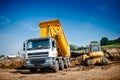 Dumper truck and bulldozer at road construction site Royalty Free Stock Photo