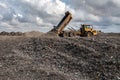 Dumper truck unloading on landfill site Royalty Free Stock Photo