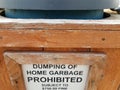 Dumping of home garbage prohibited fine 750 dollars sign on trash can