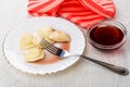 Dumpling with syrup in plate, napkin, bowl with syrup, fork