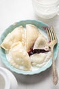 Dumplings with blueberries and cream. Sweet pierogi with berry fruit.