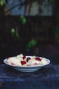 Dumplings with cherries in a plate on a dark retro background Royalty Free Stock Photo