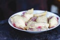 Dumplings with cherries in a plate on a dark retro background Royalty Free Stock Photo