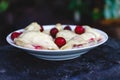 Dumplings with cherries in a plate on a dark retro background Royalty Free Stock Photo