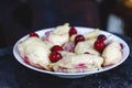 Dumplings with cherries in a plate on a dark retro background Royalty Free Stock Photo