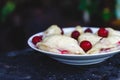 Dumplings with cherries in a plate on a dark retro background Royalty Free Stock Photo
