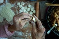 The old man`s hands are making dumplings.