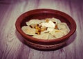 Dumplings in a clay plate on the wooden table. Dumplings, filled with mashed potato. Varenyky, vareniki, pyrohy -