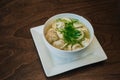 Dumplings with meat in broth with herbs in a white plate on a dark background. Russian folk cuisine. White bowl on a wooden table Royalty Free Stock Photo