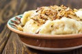 Dumplings with meat and onions. Selective focus. Close up fresh boiled dumplings with hot steams on wood plate. Chinese food on ru