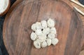 Dumplings plate and bowl of flour on dark surface Royalty Free Stock Photo