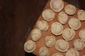 Dumplings on a wooden board. Top view on wooden table with homemade food. Uncooked handmade dumplings on a wooden plate