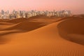Dunes of Desert at dawn and skyscrapers of Dubai United Arab Emirates