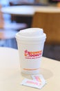 Dunkin donuts cup of hot coffee and sugar sachet on table