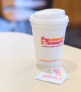 Dunkin donuts cup of hot coffee and sugar sachet on table Royalty Free Stock Photo