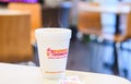 Dunkin donuts cup of hot coffee and sugar sachet on table Royalty Free Stock Photo