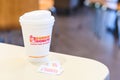 Dunkin donuts cup of hot coffee and sugar sachet on table